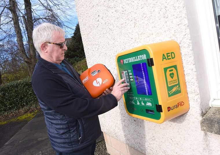 Martin Stuart of Friends of Forth Valley First Responders putting a defibrillator into public access box