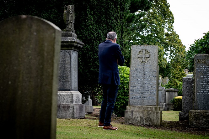 Kenneth takes time to reflect at a family grave